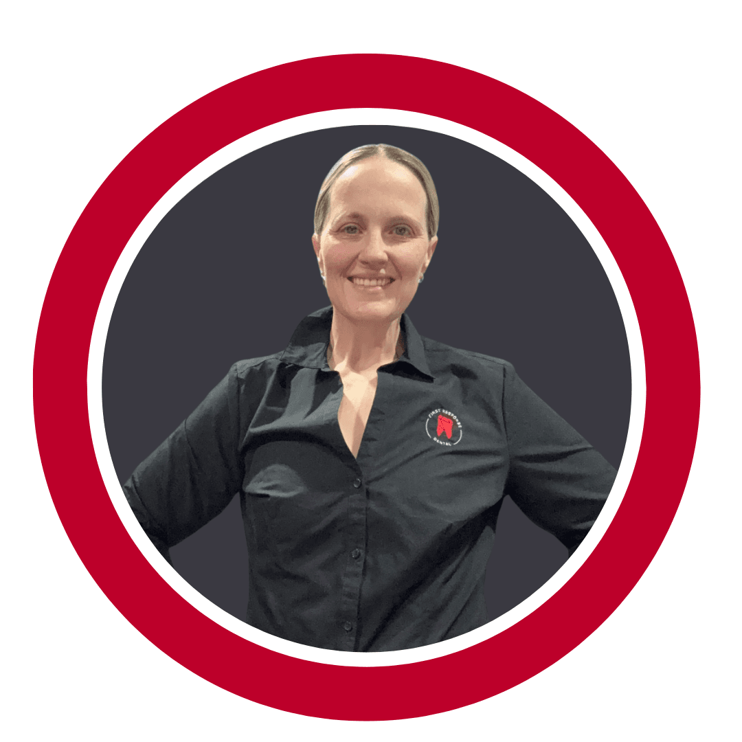 Kelly - Mid Body Shot Image of Keith Evans, in a red circle, tattooed arms are crossed in front of his body, wearing black polo shirt with the red tooth logo